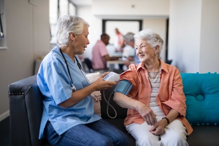 Nurse Checking Senior Woman Blood Pressure